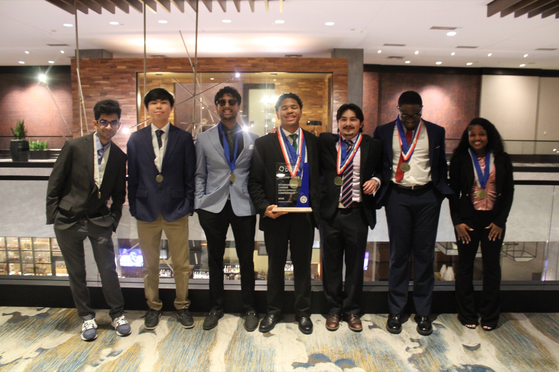 UNC Charlotte Collegiate DECA group with medals and second-place award