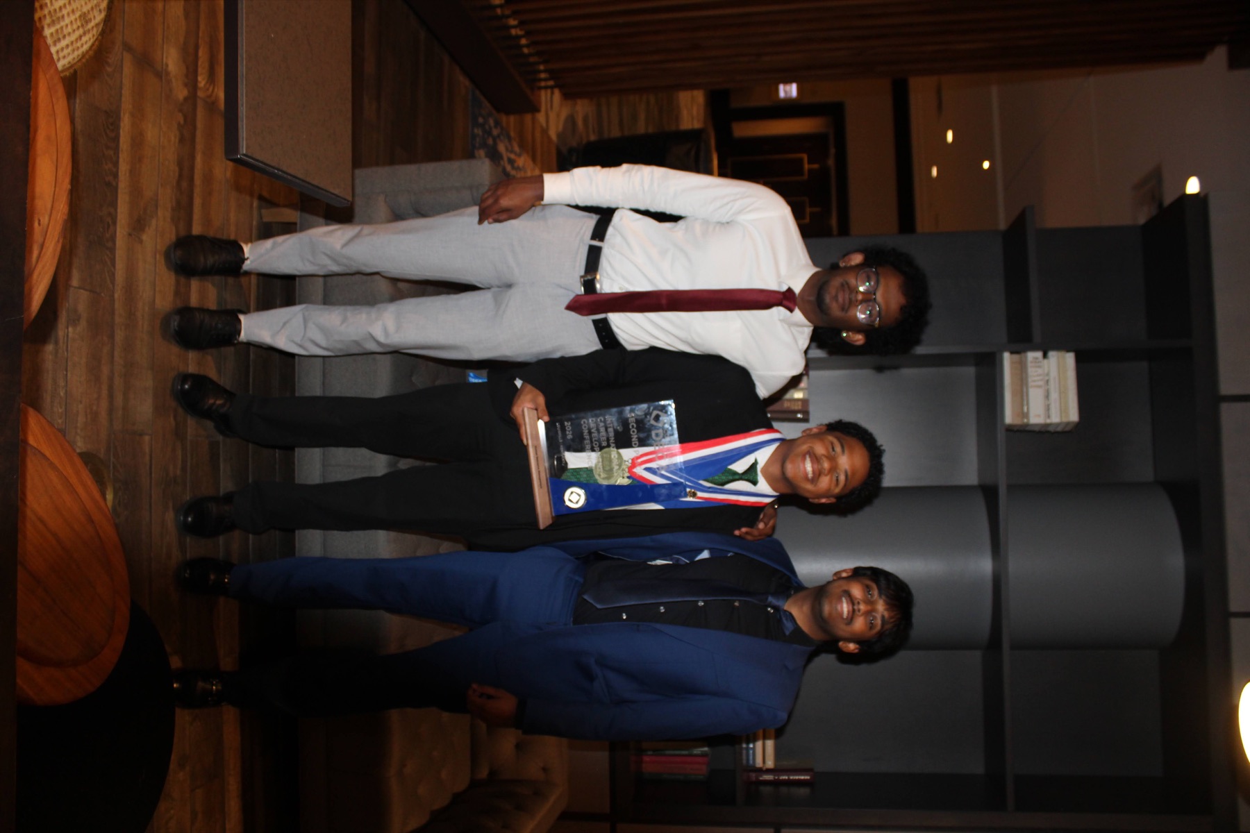 Three chapter members posing with the second-place trophy